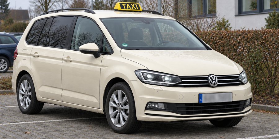 Taxi Naseer, ein cremefarbener VW Touran mit Dachzeichen